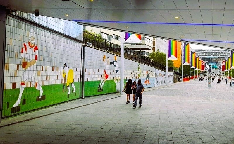 Sports Heritage Murals On East Wall Of Olympic Way, 2022. The murals depict scenes from the sports and entertainment heritage of Wembley Stadium and Arena. Image Credit: Philip Grant. Permission to use with all LDRS partners.