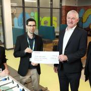 Redrow London sales director Jody Bryant hands a donation to Unitas Barnet Youth Zone