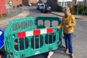 Alison Hopkins next to the sink hole that following repairs is at risk of sinking again