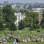 People enjoy the hot weekend weather and the views on north London's Primrose Hill.