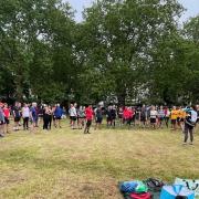 Pre-run briefing; parkrunners distanced and listening intently.