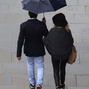 A couple walking in the rain in the City of London.