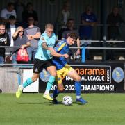 Wealdstone midfielder Charlie Cooper battles for the ball at King's Lynn Town
