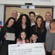 Jack Singer with sister Chloe handing their cheque to Northwick Park Hospital staff